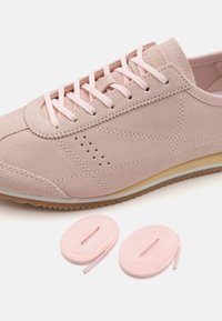 Vaaleanpunaiset mokkanahkaiset kengät, joissa on teksturoitu pinta, nyöritys ja rei'itetyt yksityiskohdat. Mukana kaksi ylimääräistä vaaleanpunaista nauhaa.