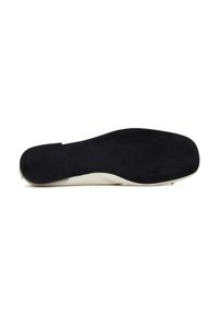 Suela de zapato negra con una superficie texturizada y lateral blanco, que presenta una punta redondeada y un tacón plano. Acabados suaves y acentos sutiles.