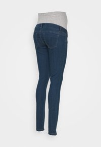 Gravidjeans med en grå, stretchpanel i midjan. Mörkblå denim, slim fit, fem fickor, diskreta söm detaljer.