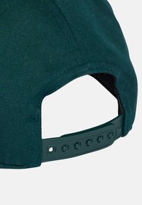 Gorra de color verde oscuro con un tejido texturizado, con un ala curva y un cierre ajustable tipo snapback con varios botones para ajustar el tamaño.