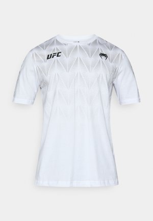 Maglietta bianca a maniche corte con motivo a foglia in rilievo, con logo UFC nero e dettaglio a forma di cuore sul petto. Materiale in cotone.