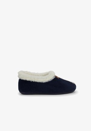 Zapatillas de color azul marino con un suave forro de piel sintética blanca, punta redonda y un exterior texturizado, que cuenta con un pequeño logo de acento marrón.
