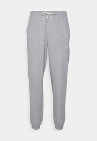 Pantaloni de trening gri deschis, confecționați dintr-un material moale, având un talie cu șnur, manșete elastice și un mic logo alb pe coapsa stângă.