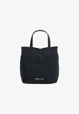 Sac fourre-tout noir en tissu, avec deux poignées robustes, une forme structuré et un logo blanc en bas. Design minimaliste.
