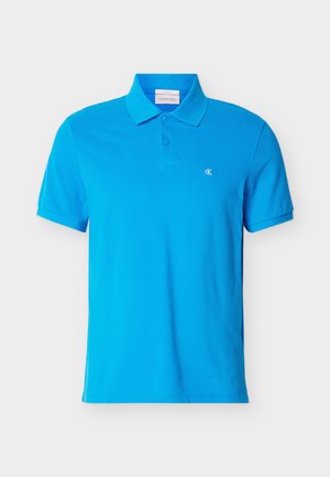 Sinine lühikeste varrukatega polo-särk kraega ja kahe nupuga nööbitav, vasakul rinnal väike valge "cK" logo.