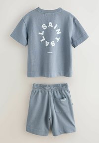 Ensemble chemise à manches courtes en coton bleu et short à taille élastique avec le texte "ALLSAINTS LONDON", posé à plat sur un fond clair.
