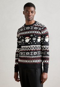 Sweater de malha preto com padrões festivos de Natal, incluindo rostos do Pai Natal, flocos de neve e designs geométricos em vermelho e branco. Punhos e bainha canelados.