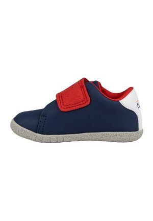 Zapatilla de color azul marino con acentos rojos, una correa de Velcro y suela texturizada gris. Material superior suave con un diseño de corte bajo.