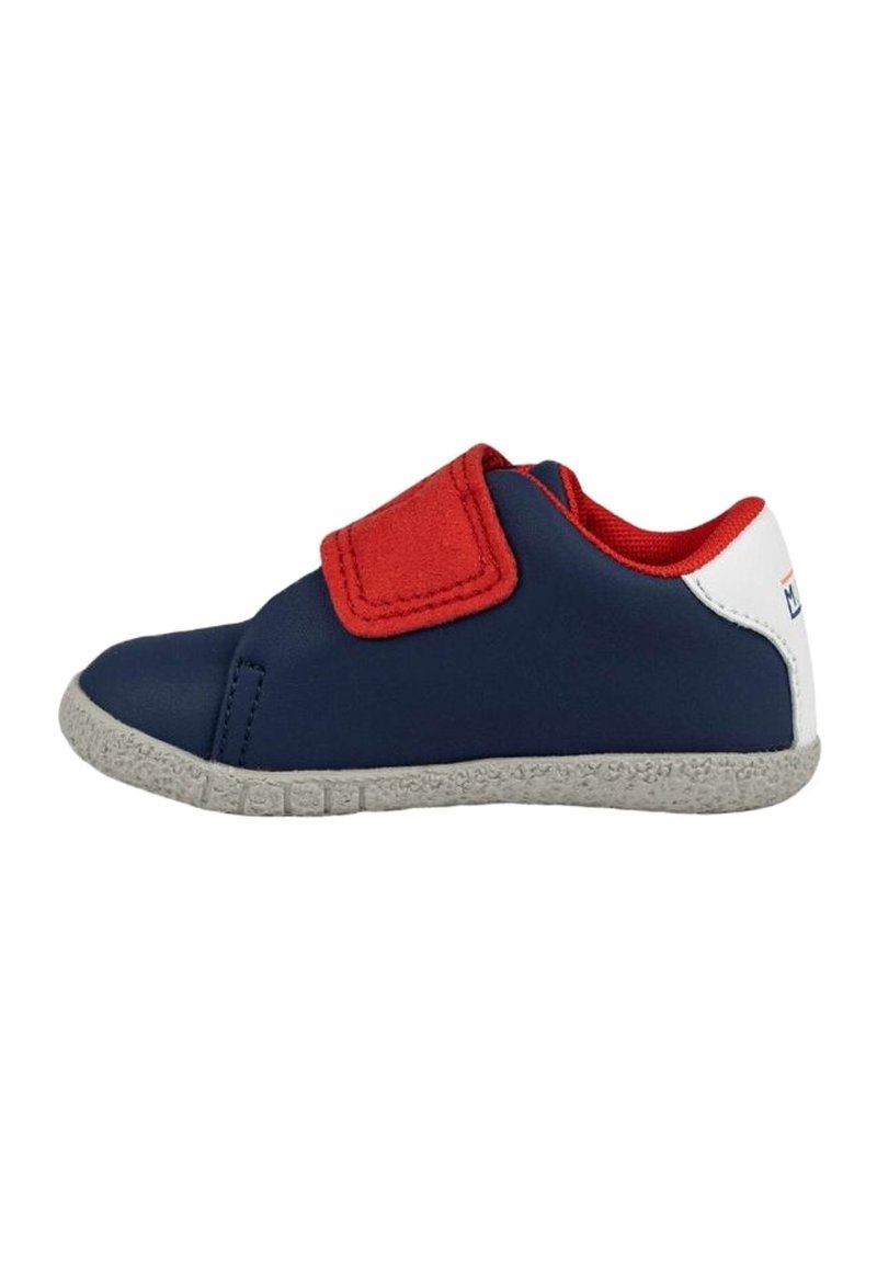 Zapatilla de color azul marino con acentos rojos, una correa de Velcro y suela texturizada gris. Material superior suave con un diseño de corte bajo.