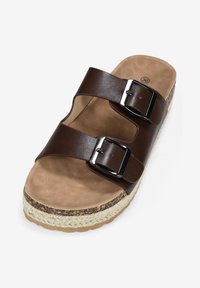 Sandalo in pelle marrone con due cinturini regolabili, fibbie in metallo e suola in giuta intrecciata. Sottopiede morbido color tan con superficie testurizzata.