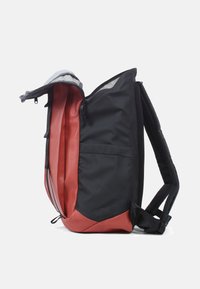 Rugzak met een zwarte buitenkant en een rode binnenkant, gemaakt van duurzaam stof, met een ritssluiting en verstelbare gewatteerde schouderbanden voor comfort.