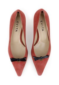 Tacchi a punta in suede corallo con un accento a fiocco nero nella parte anteriore. L'interno è beige con il nome del marchio "EVITA" stampato. Texture liscia.