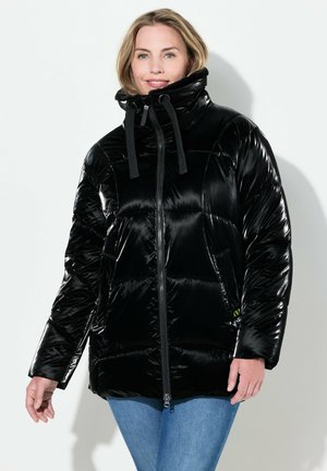 Chaqueta acolchada negra con textura brillante, cuello alto y cordones ajustables. Cierre frontal y diseño de panel con un detalle de logo sutil.