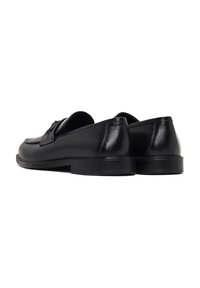 Schwarze Lederloafers mit glatter Oberfläche, runder Zehenform und niedrigem Absatz. Sie verfügen über minimale Nähte und ein einfaches, elegantes Design.