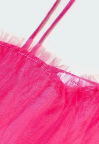 Top rosa transparente con tirantes finos, un dobladillo con volantes y una textura suave de tul. Etiqueta visible en la zona del escote.