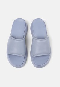 Sandali pupazzetti di colore lilla con tomaia in pelle liscia, fascia larga e suola flessibile; design minimalista senza ulteriori motivi o accenti.