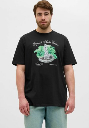 Black cotton t-shirt with a graphic print of a statue surrounded by green foliage and text reading "Originals Studio Edition." Light denim jeans.