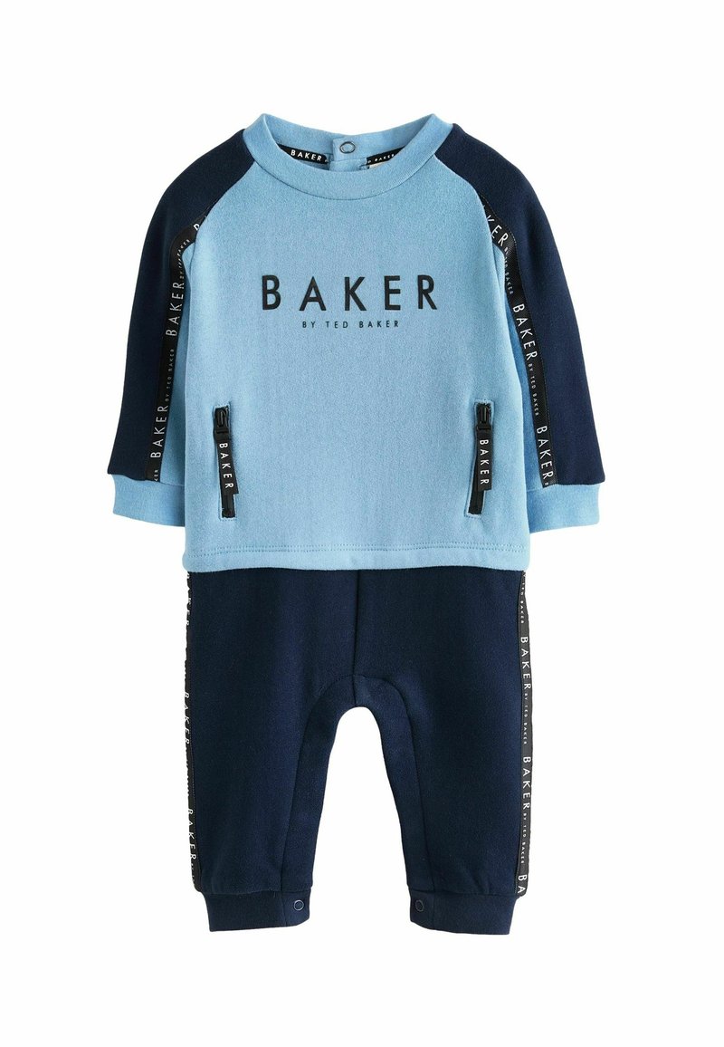 Chándal azul y marino con mangas largas, logo frontal "BAKER" y acentos de cremallera en los laterales. Tejido suave con puños acanalados y aberturas en los tobillos.