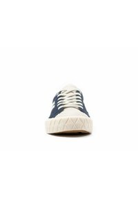 Mörkblå och krämfärgad sneaker med en strukturerad gummisula, som har rund tå, snörning framtill och en triangulärt mönstrad sula.