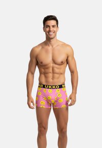Boxers rosa que presentan un patrón de caras sonrientes, con una cinturilla negra que lleva el texto "MR UKKO", fabricados en tejido elástico para mayor comodidad.