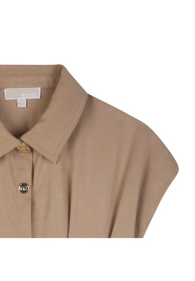 Μπεζ πουκάμισο με κουμπιά, με διακοσμητικό γιακά, κοντά μανίκια τύπου καπάκι και ένα κουμπί με λογότυπο στο μπροστινό μέρος. Λεία υφή, εφαρμοστή γραμμή.