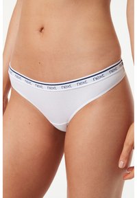 String en coton blanc avec une ceinture contrastante bleu marine comportant le mot "next" imprimé dans un motif répété. Texture lisse et design simple.