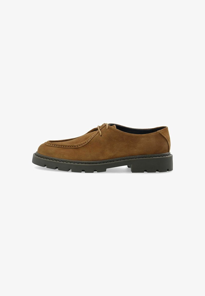 Chaussure marron en daim à lacets avec semelle épaisse en caoutchouc noir et bout arrondi, vue de côté sur fond blanc.