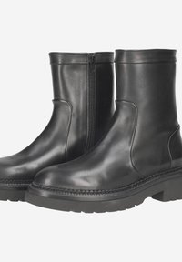 Black leather ankle boots with a smooth finish, side zipper, and a thick rubber sole featuring textured detailing along the edge.