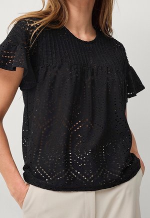 Haut noir à manches courtes comprenant un motif en œillets dentelle, des rayures texturées et des manches à volants pour plus de détails.