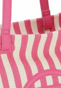 Sac fourre-tout rayé en tissu texturé rose et crème, avec deux poignées synthétiques roses et un accent circulaire rose à la base.