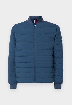 Marineblauwe gewatteerde jas met gecamoufleerd ontwerp, ribgebreide manchetten en een staande kraag. Inclusief een logomerk op de linkerborst en een ritssluiting.