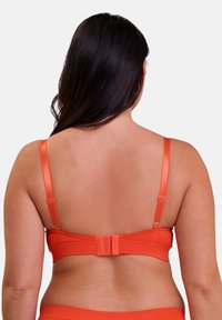 Oranje beha met satijnen straps, haak-en-oog sluiting op de rug, gladde textuur en een eenvoudig ontwerp, zonder opvallende patronen of accenten.