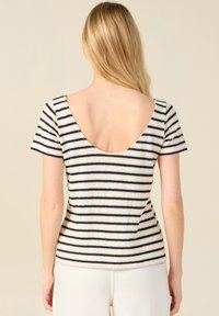 Top de rayas de manga corta con un escote bajo, con rayas horizontales en azul marino y crema, textura suave y un diseño ajustado.
