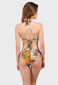 Bikini set s mnohofarebnou tropickou potlačou, dizajnom s viazaním za krkom a viazacími detailmi na vrchu a po stranách spodného dielu.