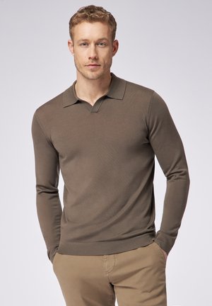 Brauner Langarm-Polo-Pullover mit V-Ausschnitt, gerippten Bündchen und glatter Textur, kombiniert mit hellbeigen Hosen.