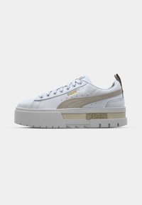 Sneaker platform bianco Puma con striscia in suede beige, suola spessa e rigida, lacci frontali e dettagli brandizzati sul lato e sul tallone.