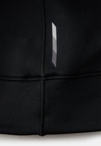 Tecido atlético preto com um padrão texturizado e um detalhe geométrico refletivo em cinza escuro de um lado. Apresenta costuras de contraste.
