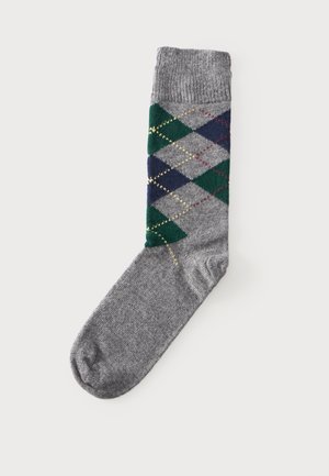 Une chaussette grise unique avec un motif losanges vert, marine et gris clair et des lignes losanges brodées en jaune et rouge.