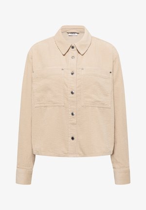 Beige corduroy overhemdjack met knoopsluiting, voorzien van twee borstzakken, een kraag en getextureerde verticale lijnen door het hele jack.