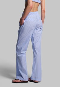 Lichtblauwe en witte gestreepte broek met een comfortabele elastische tailleband, een relaxte pasvorm en twee zijzakken, gemaakt van zachte stof.