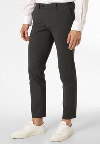Pantaloni in un elegante grigio carvão, con vestibilità slim, fronte piatto, tasche e una texture liscia, abbinate a sneakers bianche basse.