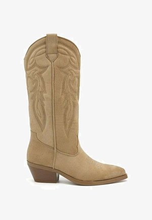 Botte de cowboy en daim beige avec coutures décoratives, bout pointu et talon empilé, vue de côté sur fond blanc.