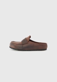 Barna bőr slip-on cipő, lekerekített orral, díszvarrással és texturált gumitalppal. Egyszerű dizájn és minimális kiegészítők.
