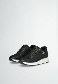 Sneaker nere con tomaia testurizzata e pannelli in rete. Presentano dettagli metallici dorati e lacci maculati. Suola in gomma bianca con dettaglio del logo.