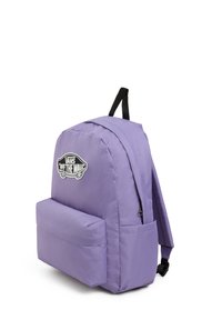 Mochila de tela morada con correas acolchadas, bolsillo frontal y un parche con el logo "Vans Off the Wall". Textura suave y forma rectangular.
