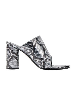 Sandale mule femme à bout ouvert avec motif peau de serpent noir et blanc et talon bloc sur fond blanc.