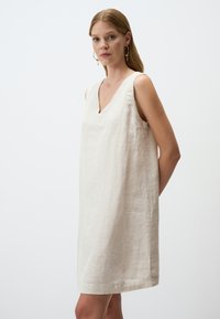 Beiges Leinen ärmelloses Kleid mit V-Ausschnitt, lockerem Schnitt, midi-länge und glatter Textur. Minimalistisches Design mit Seitennähten.