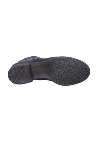 Suela de zapato de goma negra con un intrincado patrón de relieve, que presenta un pequeño tacón y un borde curvado, diseñada para ofrecer agarre y durabilidad.