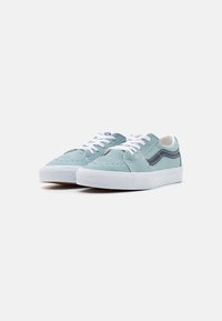Blaue Wildledersneaker mit weißen Schnürsenkeln und Gummisohlen. Verfügt über einen kontrastierenden schwarzen Seitenstreifen und Nähdetails im oberen Bereich.