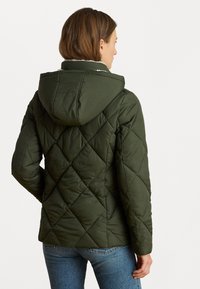 Zelená prešívaná bunda s kapucňou, s diamantovým vzorom a mäkkou podšívkou, vyrobená z textúrovanej tkaniny. Z pohľadu zozadu je vidieť priliehavý strih.